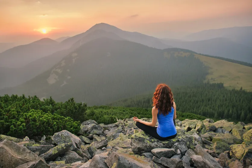 femme faisant du yoga au coucher de soleil